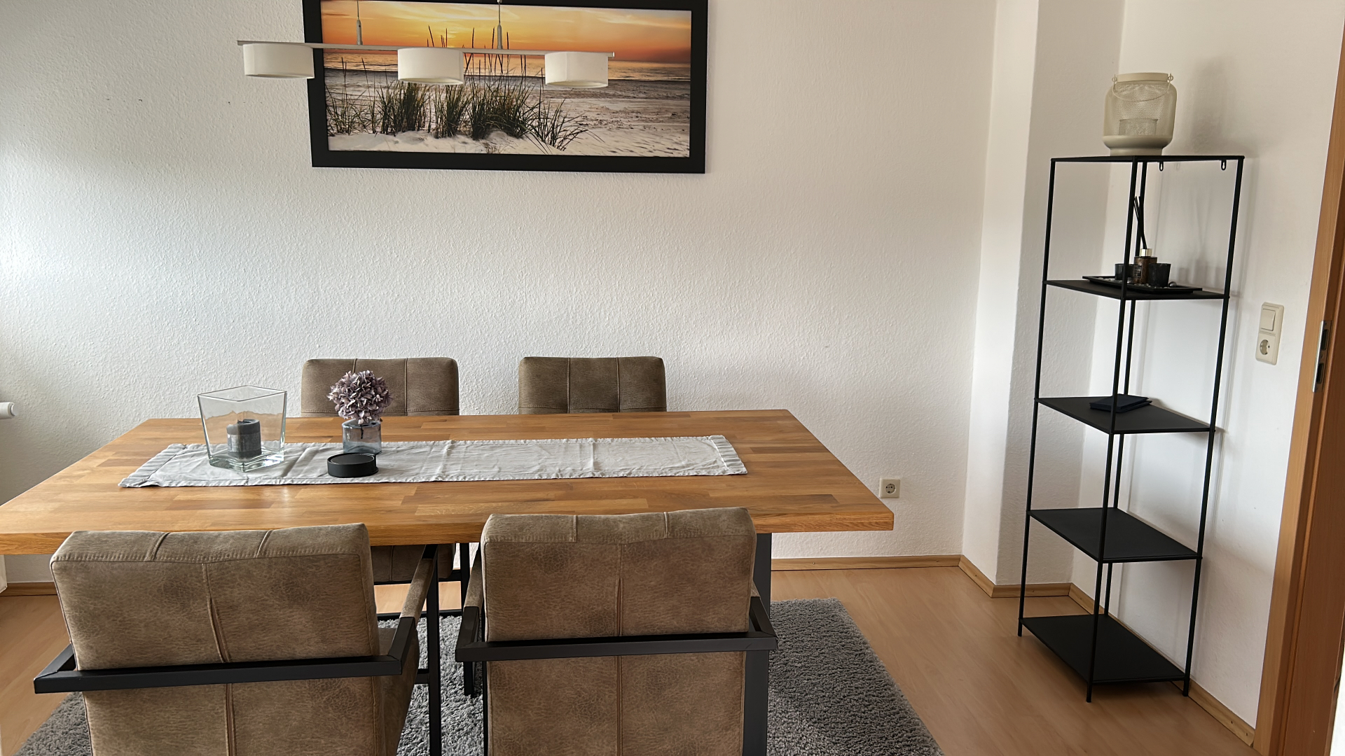 Essbereich mit Holztisch und Strandbild
