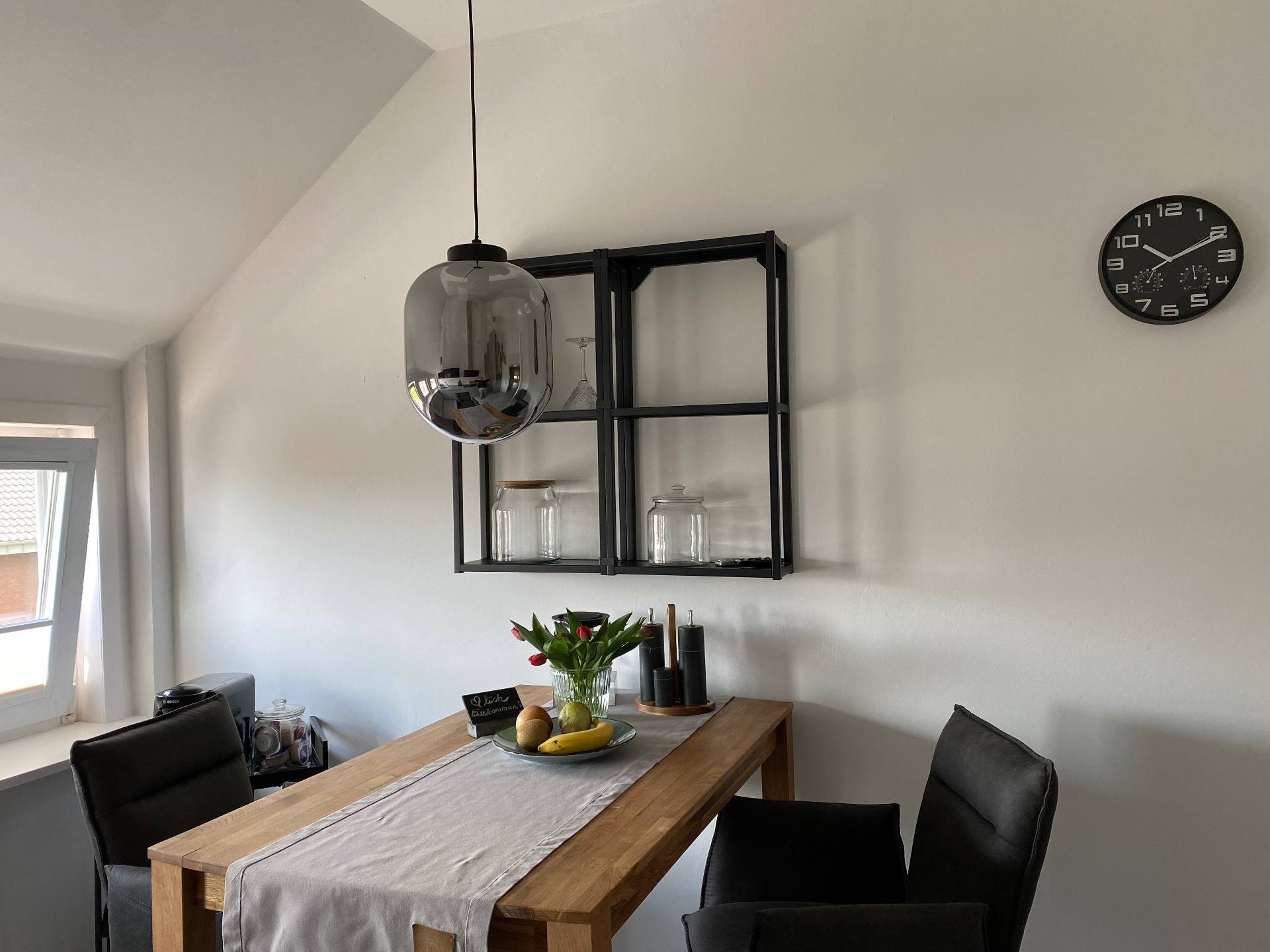 Essbereich mit Massivholztisch und Wanduhr