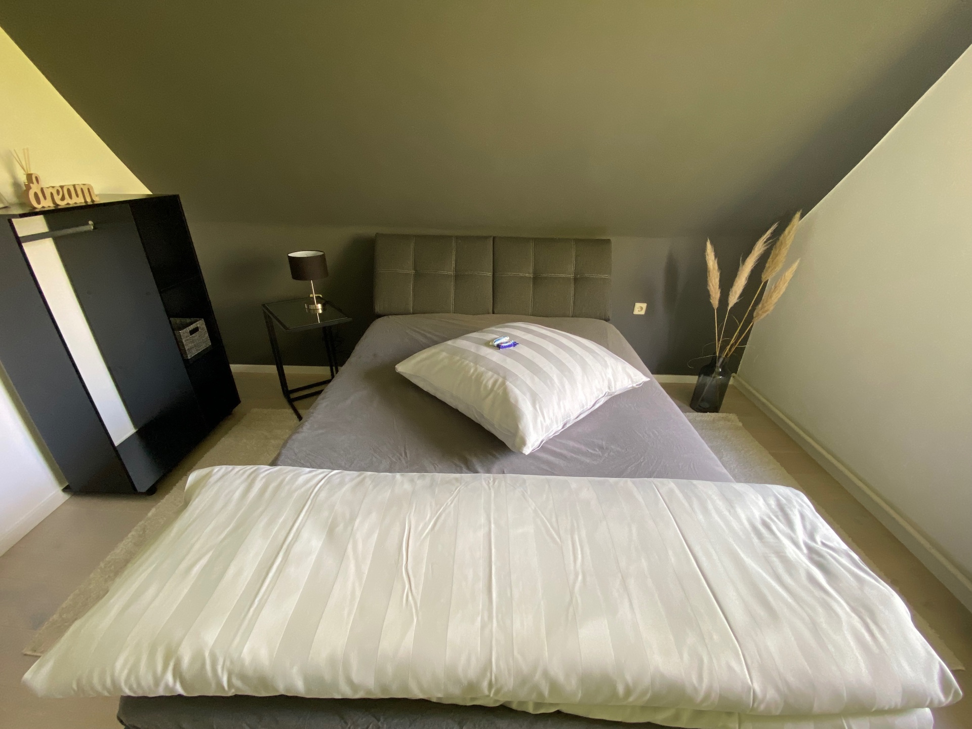 Bezogenes Doppelbett unter der Dachschräge